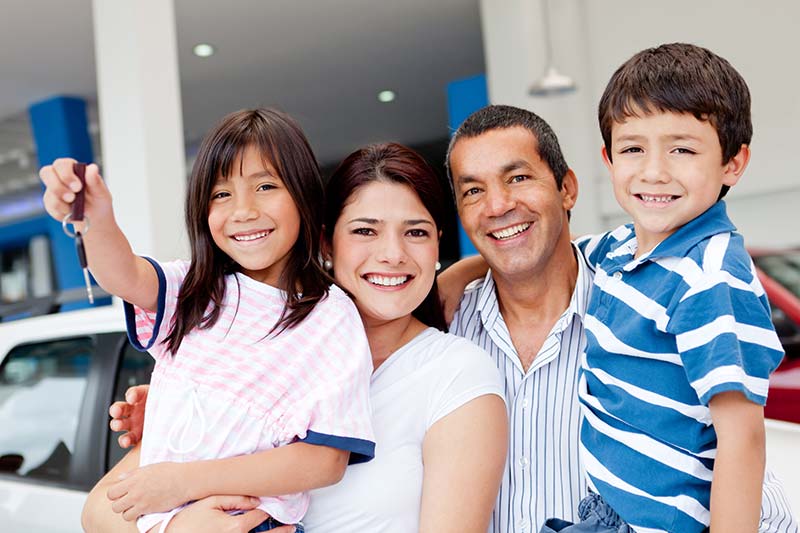 Happy Family With Daughter Holding A Set Of Keys